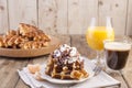 Sweet Belgian waffles for breakfast, decorated with white cream and chocolate sauce. Glass with coffee black and orange juice, Royalty Free Stock Photo