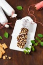 Sweet biscuit chocolate salami covered with powdered sugar on a porcelain board.