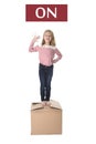 Sweet blond hair child stading on top of cardboard box isolated on white background in learning english Royalty Free Stock Photo