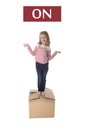 Sweet blond hair child stading on top of cardboard box isolated on white background in learning english Royalty Free Stock Photo