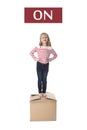 Sweet blond hair child stading on top of cardboard box isolated on white background in learning english Royalty Free Stock Photo