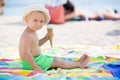 Sweet blonde toddler boy, eaiting ice cream on the beach