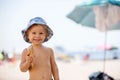 Sweet blonde toddler boy, eaiting ice cream on the beach Royalty Free Stock Photo