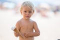 Sweet blonde toddler boy, eaiting ice cream on the beach