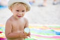 Sweet blonde toddler boy, eaiting ice cream on the beach Royalty Free Stock Photo