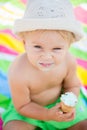 Sweet blonde toddler boy, eaiting ice cream on the beach