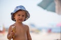 Sweet blonde toddler boy, eaiting ice cream on the beach Royalty Free Stock Photo