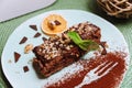 Sweet breakfast with chocolate honey biscuit cake with sour and butter cream and walnuts, a slice of dried orange