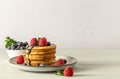 Sweet breakfast concept with american pancakes with raspberries, blueberries, and chocolate