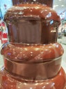 Sweet brown chocolate fountain in the shop window Royalty Free Stock Photo