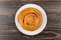 Sweet bun in white plate on dark wooden table Royalty Free Stock Photo