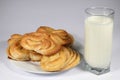 Sweet buttery pastries, cinnamon sugar buns with a glass of cow\'s milk.