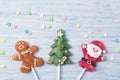 Sweet candies on a stick in shapes of Christmas tree, Gingerbread man and Santa Claus, Christmas concept on a wooden background Royalty Free Stock Photo