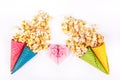 Sweet caramel popcorn and paper heart. Copy space. Origami heart of pink paper. Bright festive sweets.