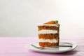 Sweet carrot cake with delicious cream on pink wooden table against light background Royalty Free Stock Photo
