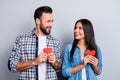 Sweet, cheerful, positive, smiling couple in shirts holding small red paper hearts in hands, having best date, looking to each ot Royalty Free Stock Photo