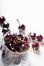 Sweet cherries in cherry glass bowl around white. close up with copy space Royalty Free Stock Photo