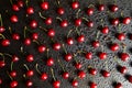 Sweet cherry background on a black table. Drops of water on the surface of the berry. View from above. Flat lay. Royalty Free Stock Photo