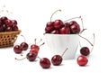 Sweet cherry berries on a white plate in a ceramic bowl and wicker basket, close-up Royalty Free Stock Photo