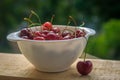 Sweet cherry berries in a white plate on a wooden background. Ripe red berries Royalty Free Stock Photo