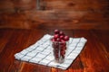 Sweet cherry, black cherries in a glass on wooden background Royalty Free Stock Photo
