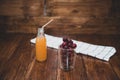 Sweet cherry, black cherries in a glass on wooden background with fresh juicy in glass bottle Royalty Free Stock Photo