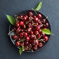 Sweet cherry in black plate on blue stone background. Royalty Free Stock Photo
