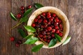 Sweet cherry with leaves in wooden bowl. Fresh ripe cherries. Cherry fruit Royalty Free Stock Photo