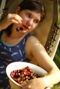 Sweet cherry merry in human hand with teenager girl on background