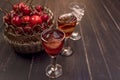 Sweet cherry,plum,quince liquein ice glass on black table and sweet cherries in golden vase Royalty Free Stock Photo
