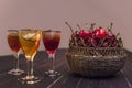 Sweet cherry,plum,quince liquer ice glass on black table and sweet cherries in golden vase Royalty Free Stock Photo