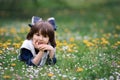 Sweet child, boy, gathering dandelions and daisy flowers