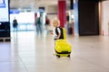 Sweet child, boy, walking at the airport, carrying suitcase and backpack