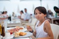 Sweet child, cute boy, eating pizza and french fries in a restaurant on the beach Royalty Free Stock Photo