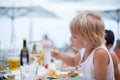 Sweet child, cute boy, eating pizza and french fries in a restaurant on the beach Royalty Free Stock Photo