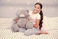 Sweet childhood. Girl child sit on bed with teddy bear in her bedroom. Kid prepare to go to bed. Pleasant time in cozy Royalty Free Stock Photo