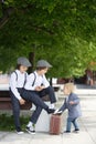 Sweet children in vintage clothing, hat, suspenders and white shirts, holding suitcase, running in the park Royalty Free Stock Photo