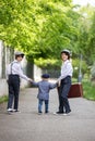 Sweet children in vintage clothing, holding suitcase, running in the park Royalty Free Stock Photo