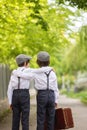 Sweet children in vintage clothing, holding suitcase, running in the park Royalty Free Stock Photo