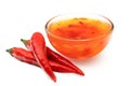 Sweet chilli sauce in a glass bowl next to three red chillies isolated on white Royalty Free Stock Photo