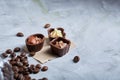 Sweet chocolate candies with coffee beans over white textured background, selective focus, close-up.