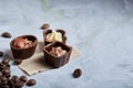 Sweet chocolate candies with coffee beans over white textured background, selective focus, close-up. Royalty Free Stock Photo