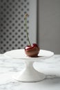 Sweet chocolate dipped cherry on white marble table Royalty Free Stock Photo