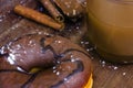 Sweet chocolate doughnut and black glass coffee cup on table with cinnamon and chocolate