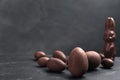 Sweet chocolate eggs and bunny on black table. Space for text Royalty Free Stock Photo
