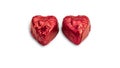 Sweet chocolate heart shaped candy wrapped in red foil papper on white background. Royalty Free Stock Photo