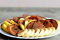 Sweet chocolate pancakes. Baked chocolate pancakes drizzled with caramel, fresh sliced bananas and apples on a plate Royalty Free Stock Photo