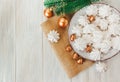 Sweet christmas background with airy meringues ,fir branch,golden acorns and balls on the plate.Rough sackcloth