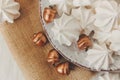 Sweet christmas background with airy meringues,golden acorns on the plate.