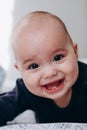 Sweet chubby cheeky baby boy lying on his tummy on the bed. Funny face expression Royalty Free Stock Photo